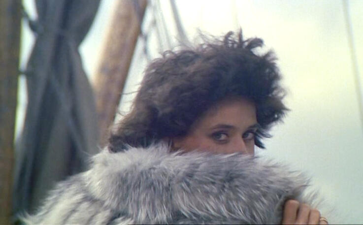 12 Lorraine Bracco looking over her shoulder behind a luxurious grey fur coat collar in a promotional still from the 1979 film Duos sur canapé.