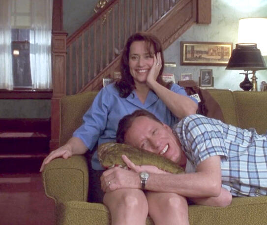 3 Lorraine Bracco smiling on a couch with James Woods resting on her thighs, from Riding in Cars with Boys.