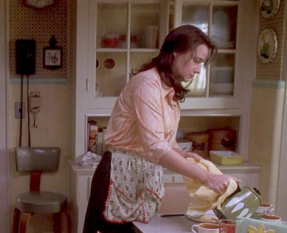 6 Lorraine Bracco in an apron pouring tea in a kitchen scene from Riding in Cars with Boys.