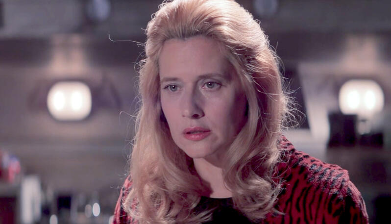 5 Lorraine Bracco with styled blonde hair looking concerned in the movie Hackers.