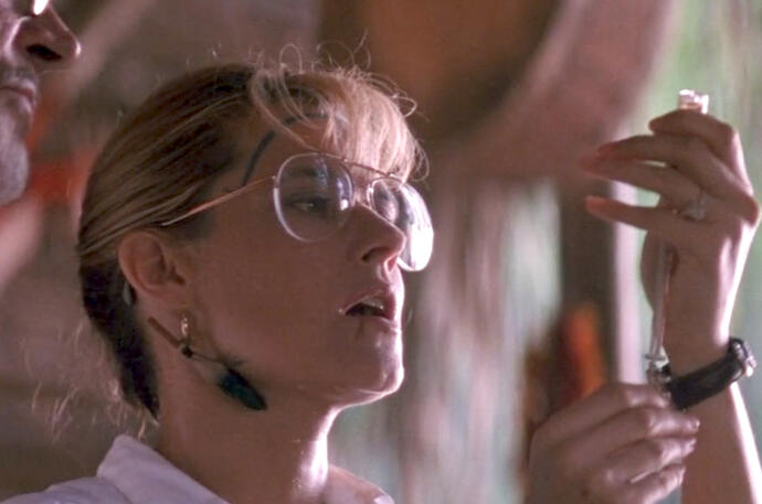 4 Lorraine Bracco with tribal face paint, looking at a syringe in Medicine Man.