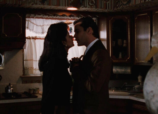 3 Lorraine Bracco and Ray Liotta about to kiss in a dimly lit kitchen scene from Goodfellas.
